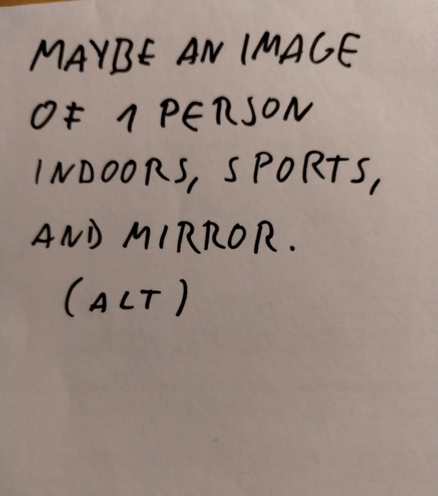 Photo of handwritten text on paper:	Maybe an image of 1 person, indoors, sports and mirror.	(ALT)