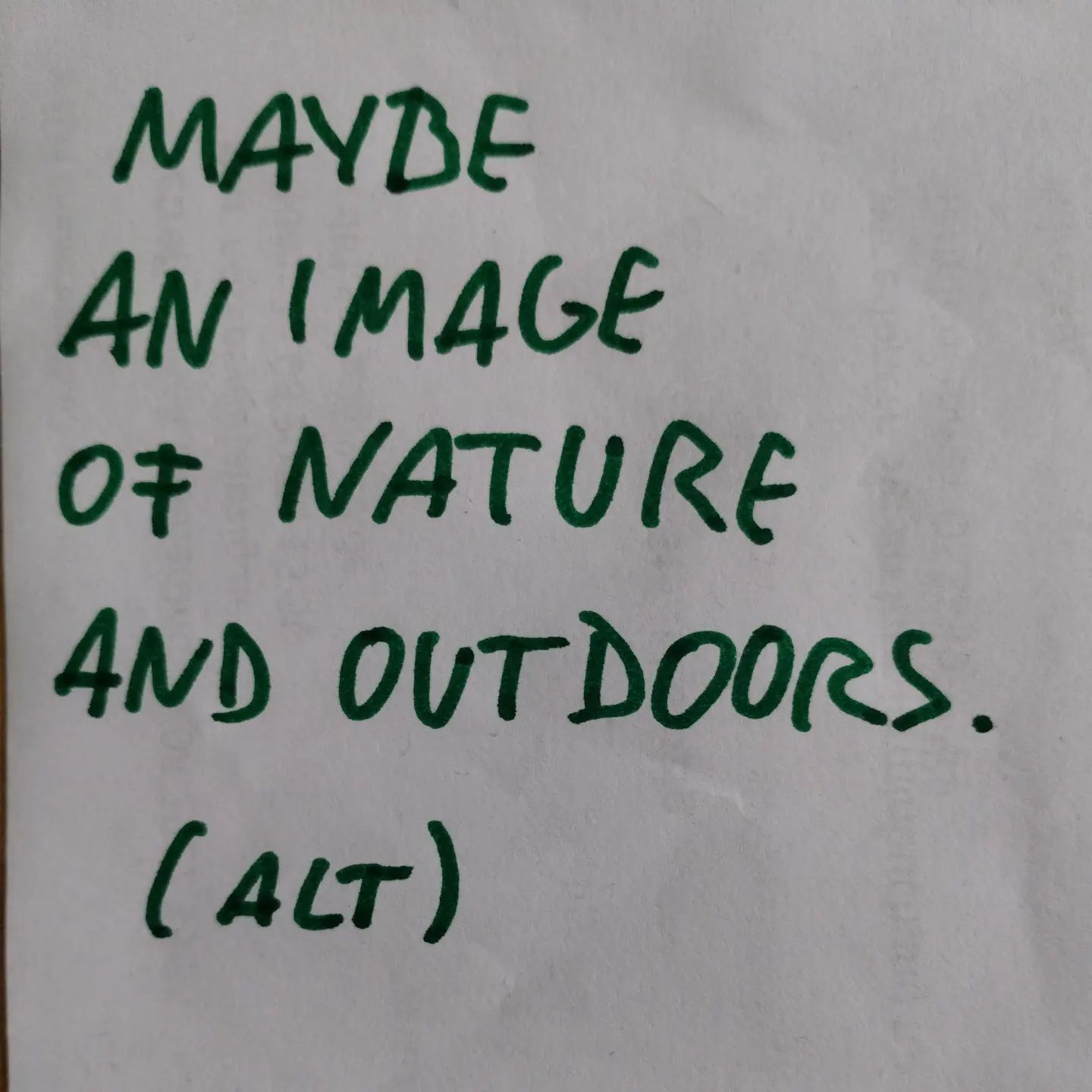 Photo of handwritten text on paper:	Maybe an image of nature and outdoors.	(ALT)