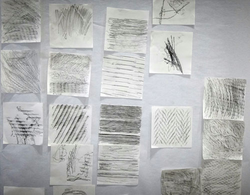 Close-up of some frottage drawings showing different linear patterns, grid structures and rough stone-like surfaces.