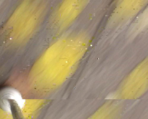 Video still showing the tip of the white cane in lower left corner and fragments of the pavement.